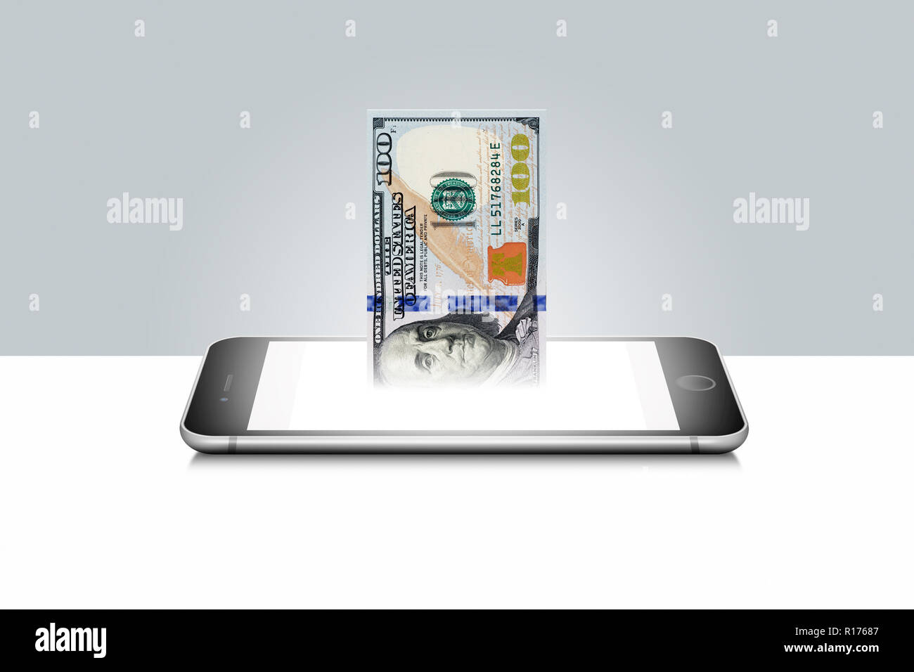 100 US-Dollar Bill aus beleuchtete Mobiltelefon Stockfoto