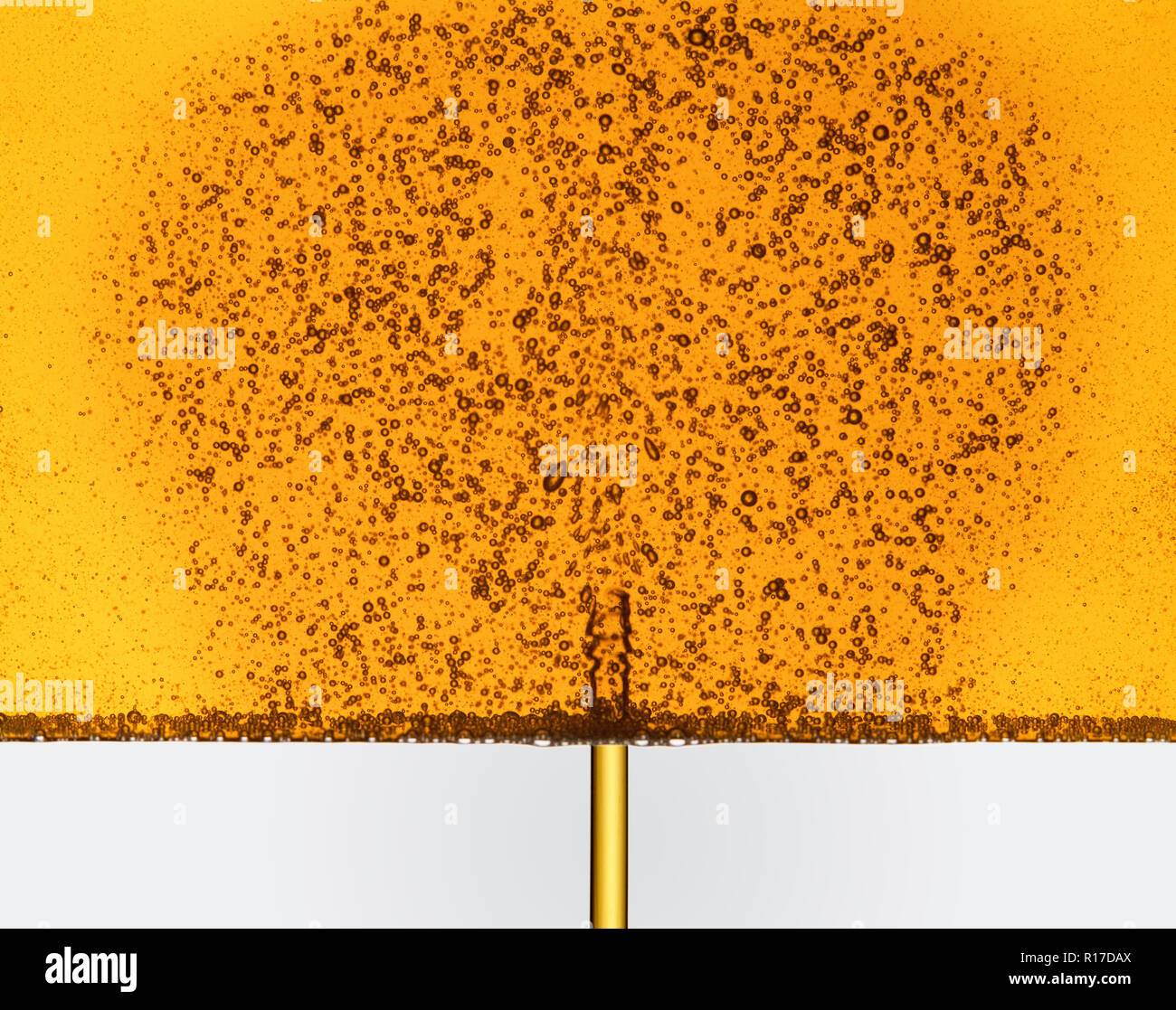 Goldene Flüssigkeit gießen und das Erstellen von Blasen, den Kopf studio Shot Stockfoto