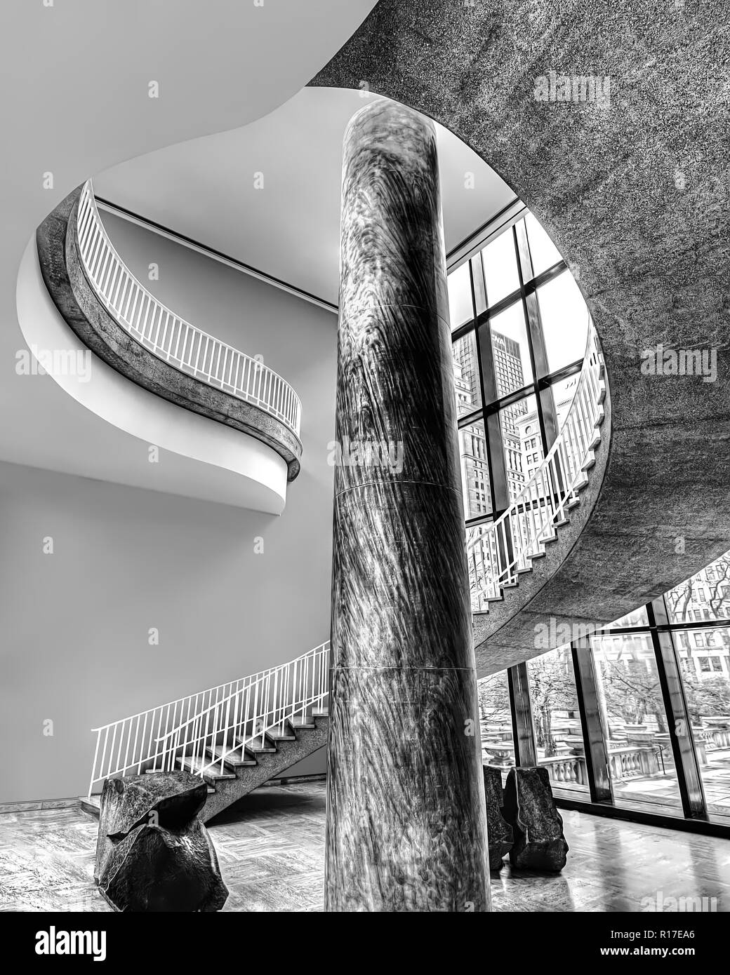 Eine dramatische, Looping, Wendeltreppe windet sich und um eine Säule in einem Gebäude für einen interessanten und artsy Winkel auf ein architektonisches Design Stockfoto