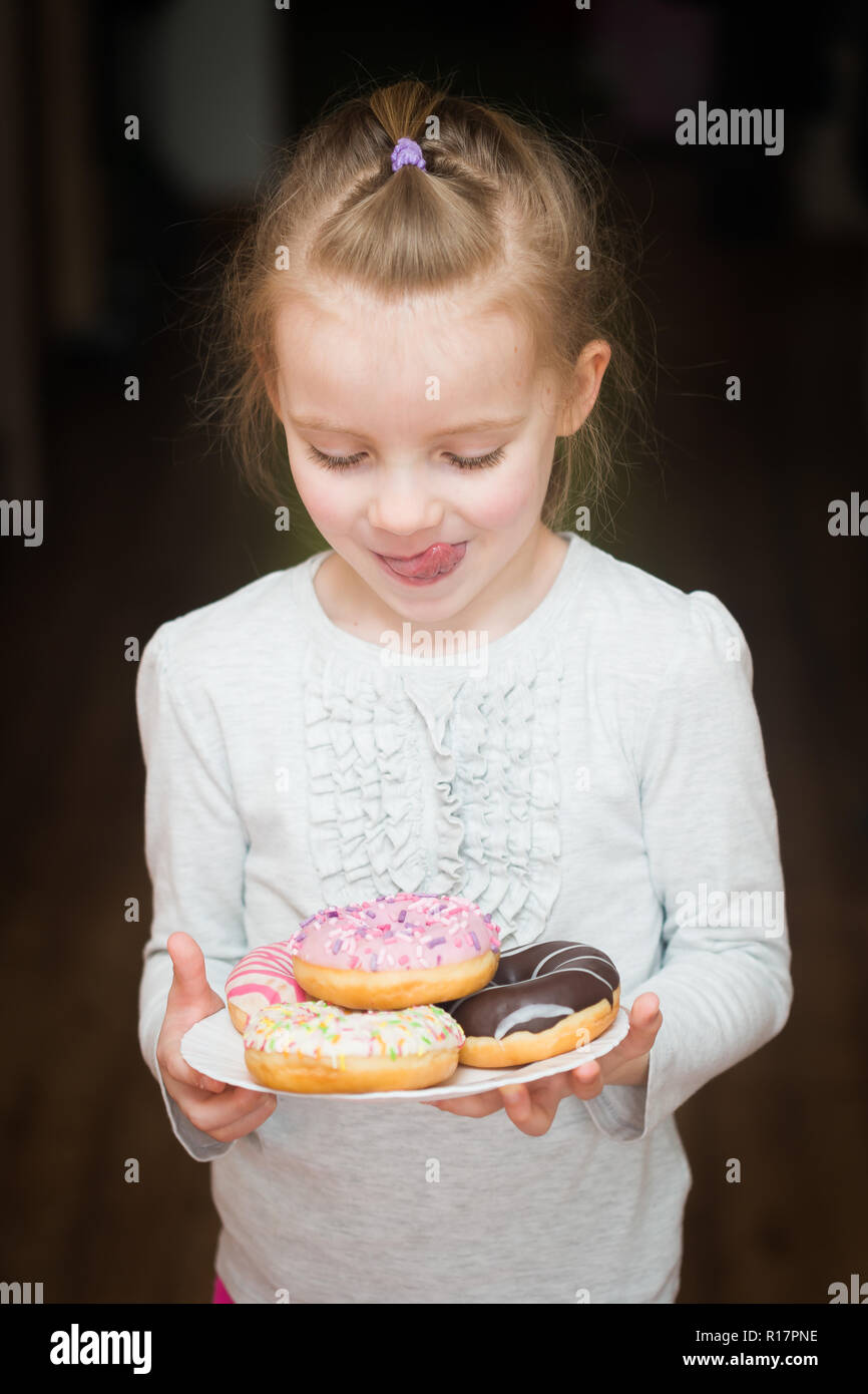Mädchen, dass eine Platte mit Donuts. Little sweetie Stockfoto