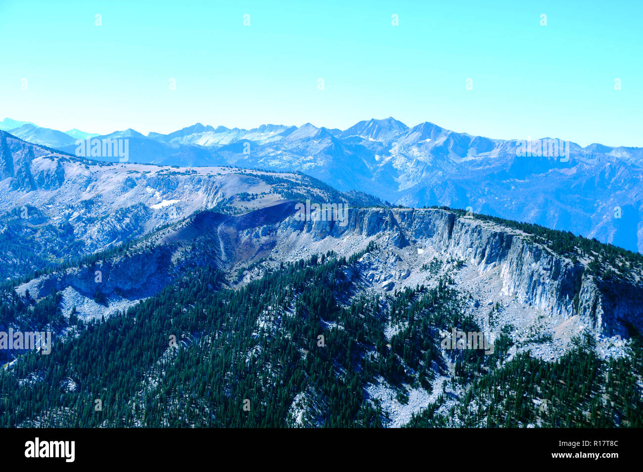 Blick von der Spitze des Berges oder Olympus zu den Gipfeln auf dem Hintergrund der Wolken und blauer Himmel. Stockfoto