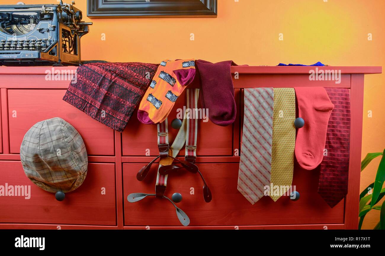 Männer Kleider. Kleidung Konzept für Männer. Farbenfrohe Socken, Krawatten, Hosenträger, Schals und geprüft, flacher Deckel auf Claret Hintergrund. Klassische Konzept von Kleidungsstücken für Männer. Wintage Schreibmaschine und mann Kleidung Stockfoto