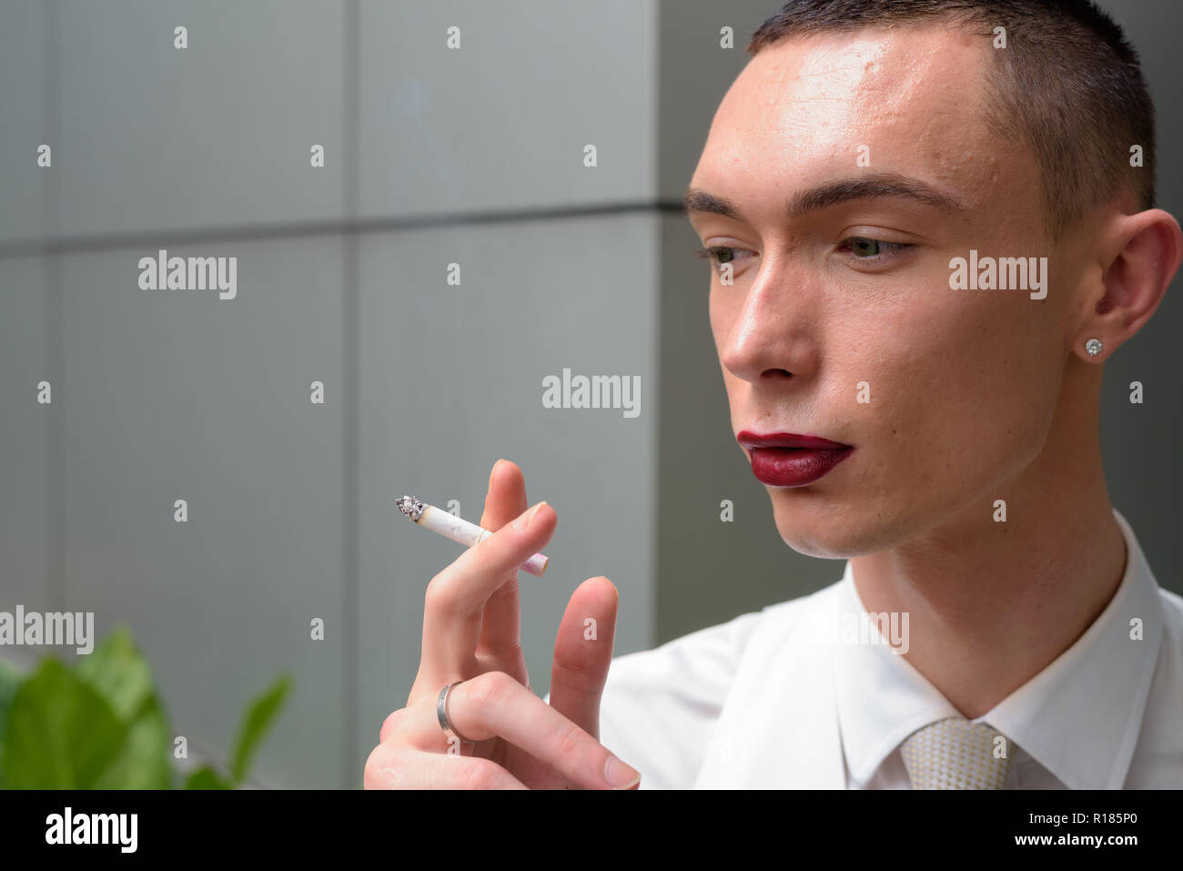 Junge androgyne homosexuellen LGTB Geschäftsmann rauchen Zigarette Stockfoto