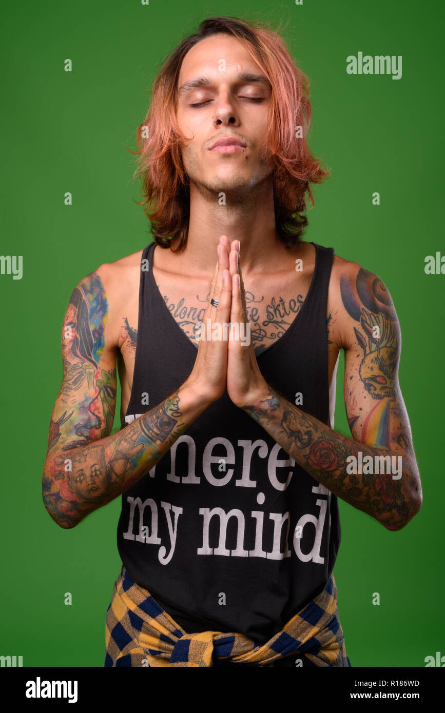 Studio shot von rebellischen jungen Mann gegen grüner Hintergrund Stockfoto