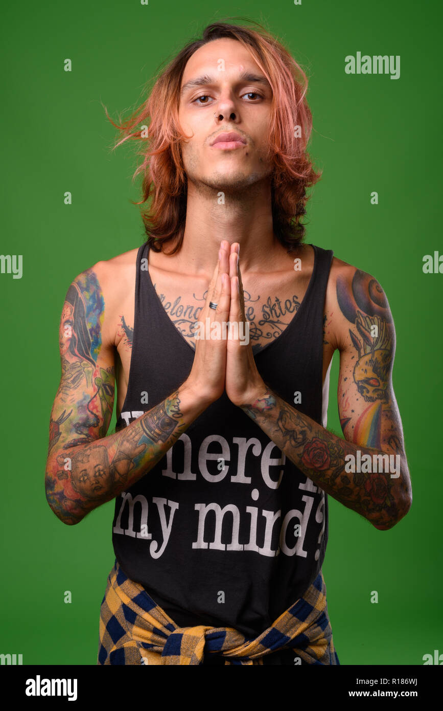 Studio shot von rebellischen jungen Mann gegen grüner Hintergrund Stockfoto