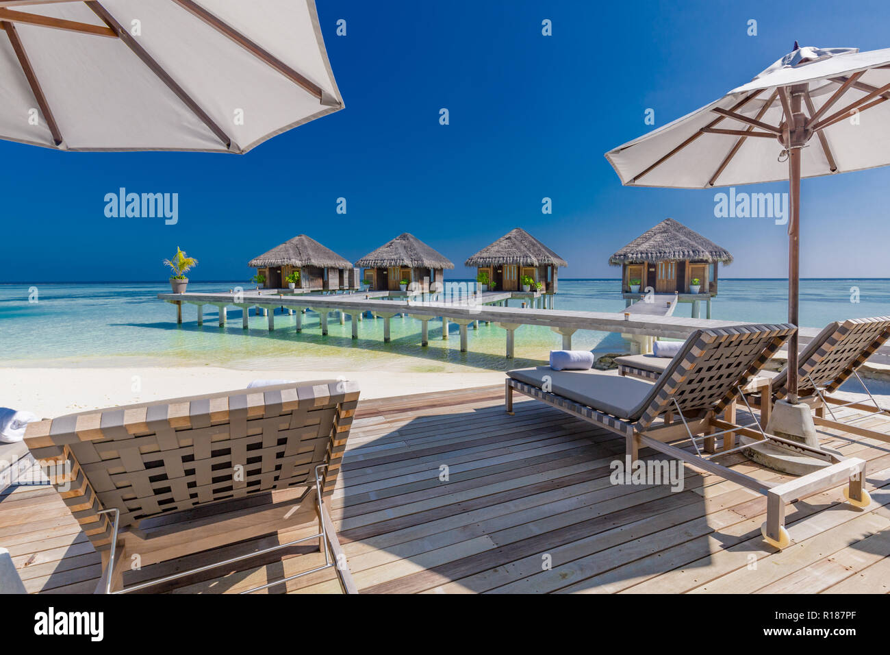 Luxury Beach spa und wellness Hintergrund, Liegen und Liegestühle mit Sonnenschirm auf Holzterrasse. Luxuriöse Resort Spa Hintergrund auf den Malediven. Stockfoto