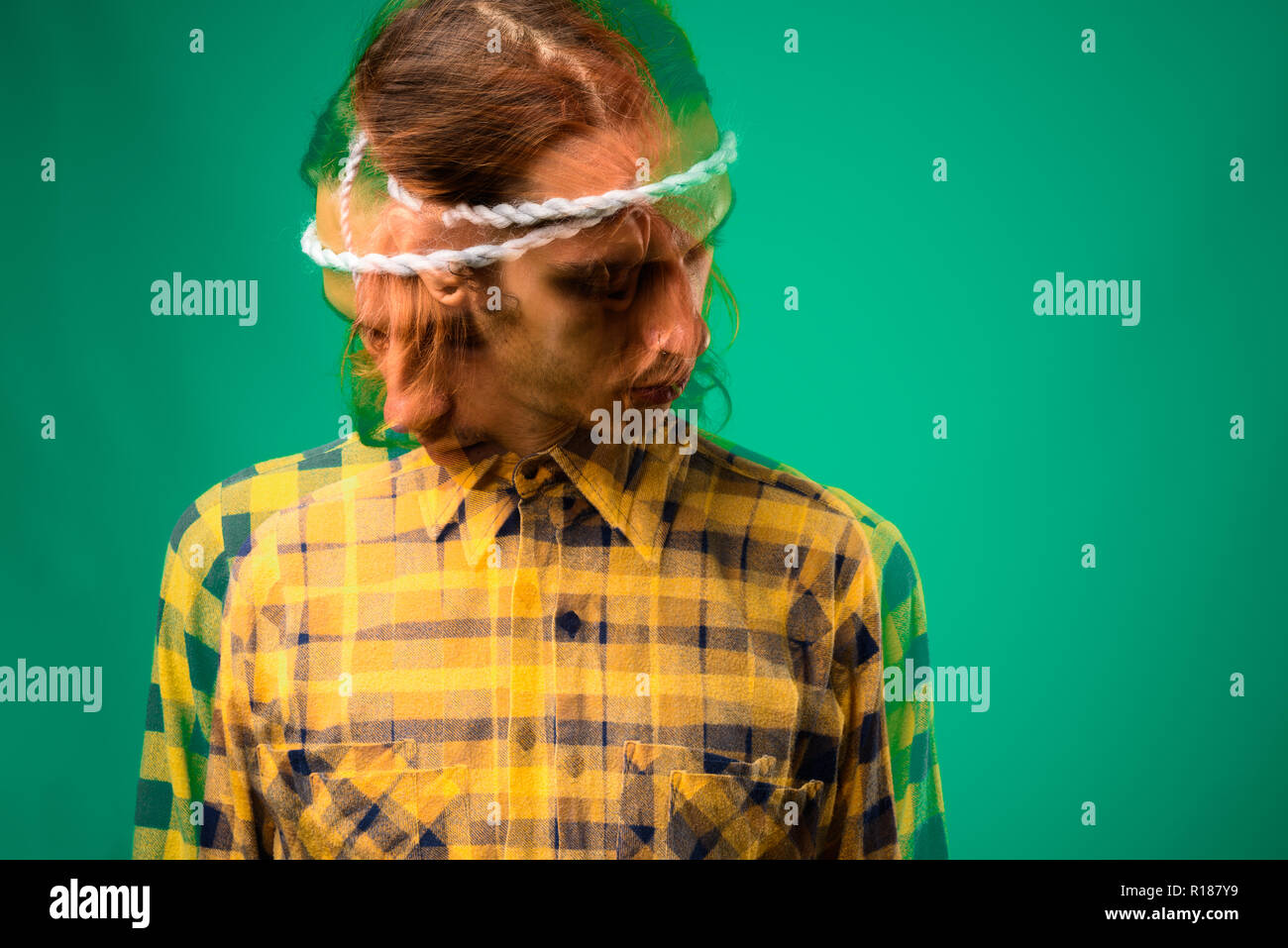 Studio shot von rebellischen jungen Mann gegen grüner Hintergrund Stockfoto
