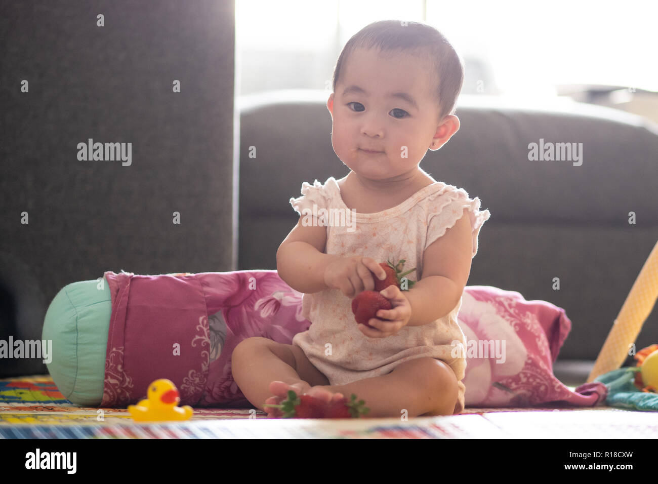 Süße 6 Monate altes Baby mit Erdbeeren Stockfoto