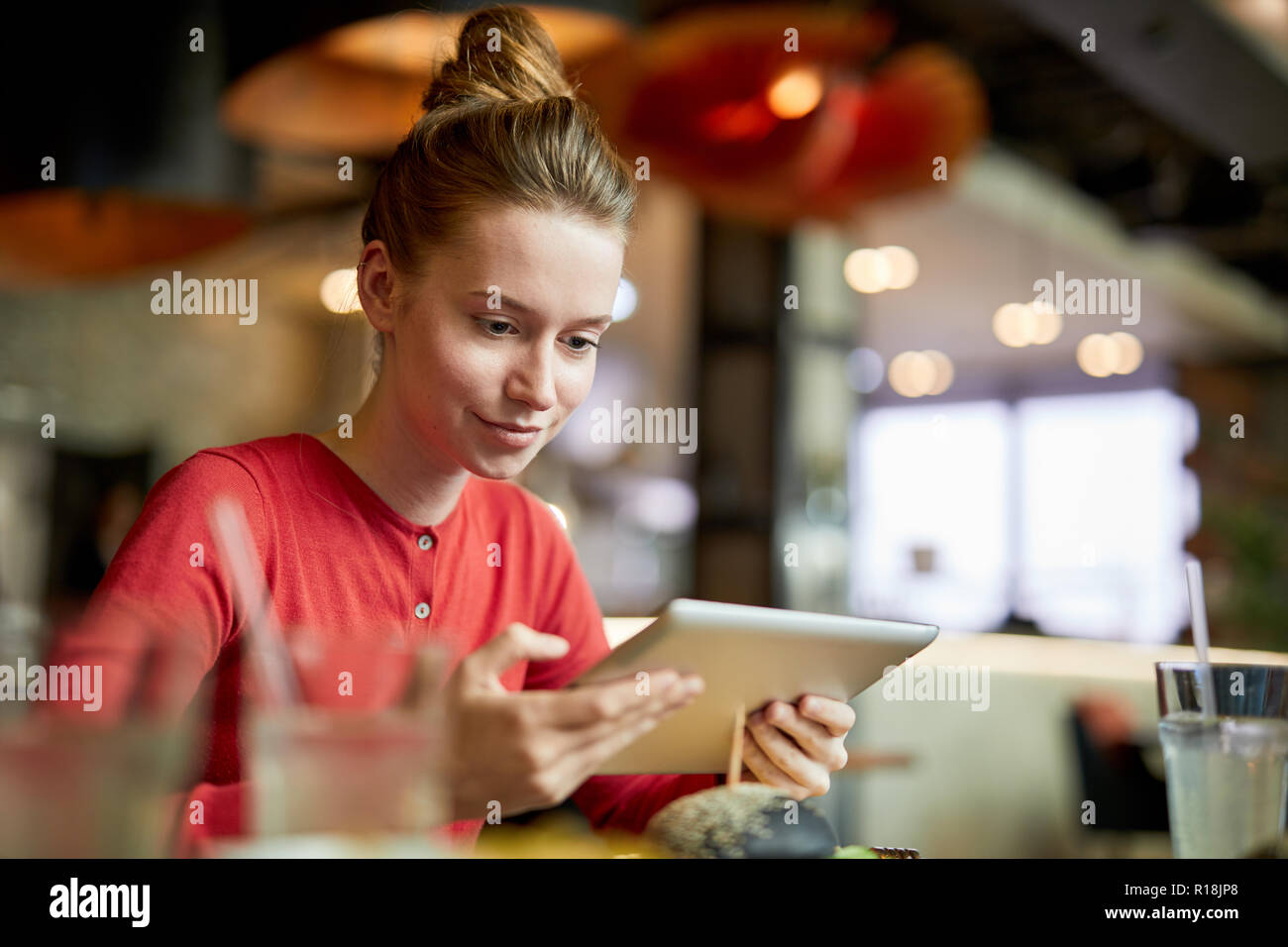 Zeitgenössische junge weibliche Blogger mit Tablet Standortwahl im Cafe und Aufzeichnung von Video für Ihr Internet Kanal Teilnehmer Stockfoto