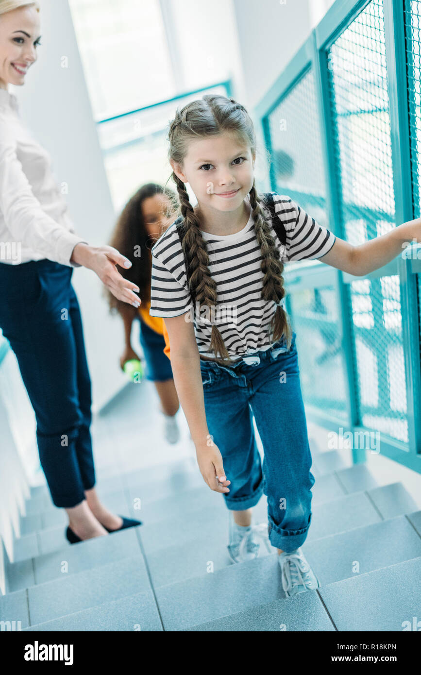 Hohe Betrachtungswinkel Schulmädchen gehen im Obergeschoss mit Lehrer in der Schule Korridor Stockfoto
