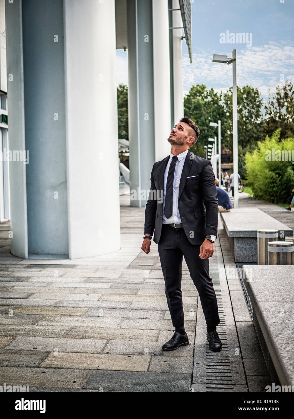 Portrait von stilvollen jungen Mann mit Anzug, stehend in der modernen Stadt Einstellung Stockfoto