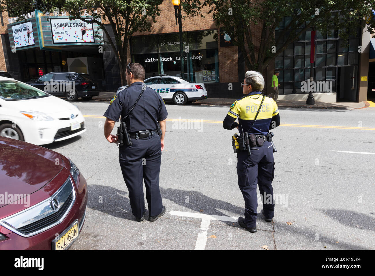 ASHEVILLE, NC, USA 10/17/18: zwei Polizisten, Mann und Frau, warten, Haywood Avenue zu überqueren. Stockfoto