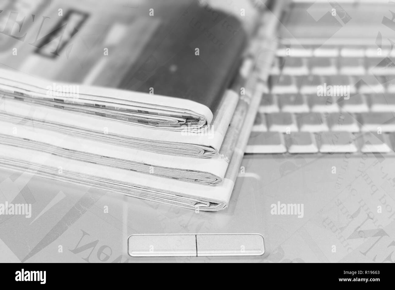 Zeitungen und Computer. Stapel von Papieren mit Nachrichten und Laptop, teilweise Wörter, Schlagzeilen und Artikel als Overlay texture gezeigt Stockfoto