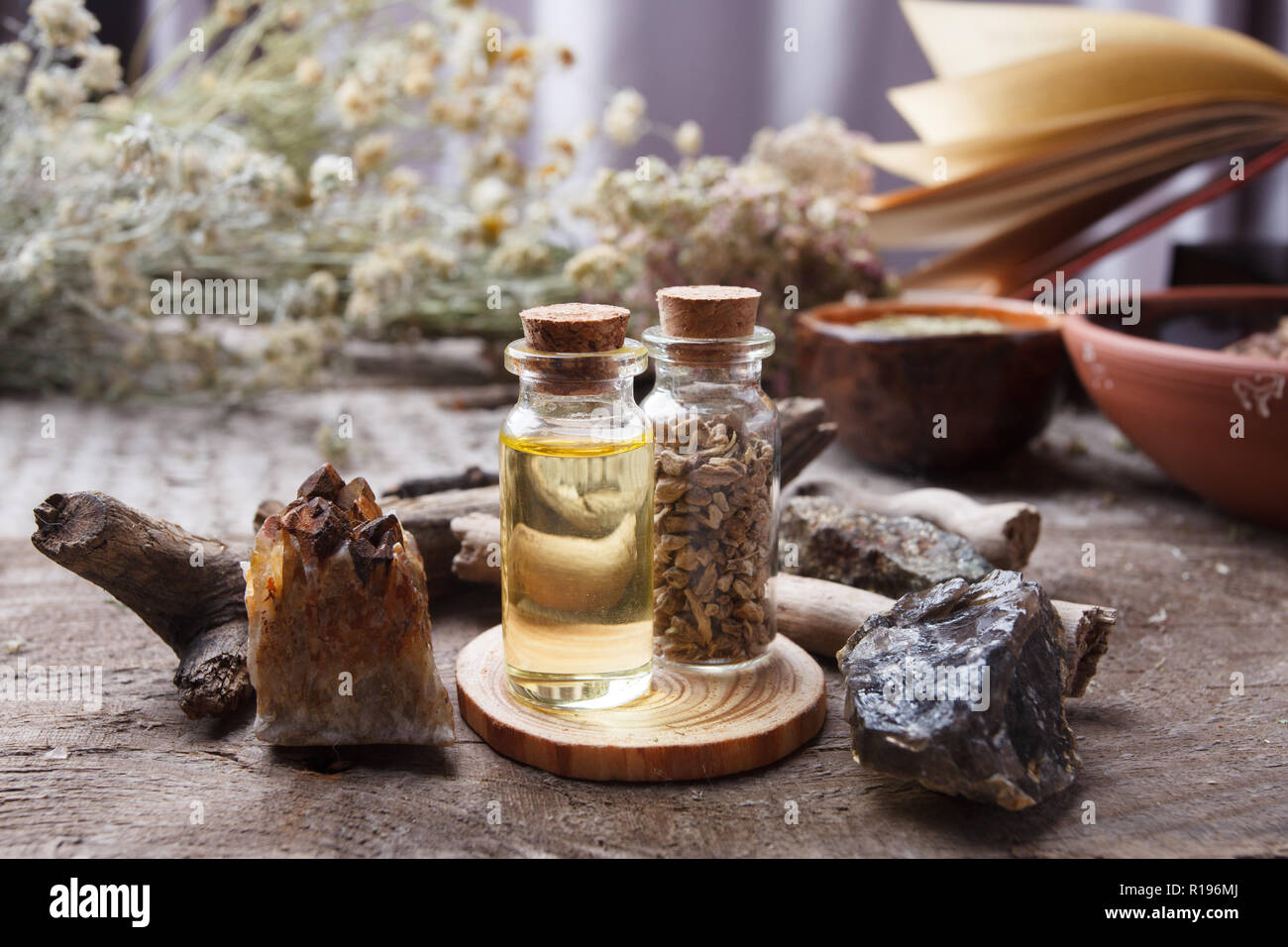 Mystische Stillleben mit alten Buch, Amulette, Stein, Flaschen. Hexerei Komposition. Halloween und okkulten Konzept, magischen Ritual. mystische und homöopathische Stockfoto