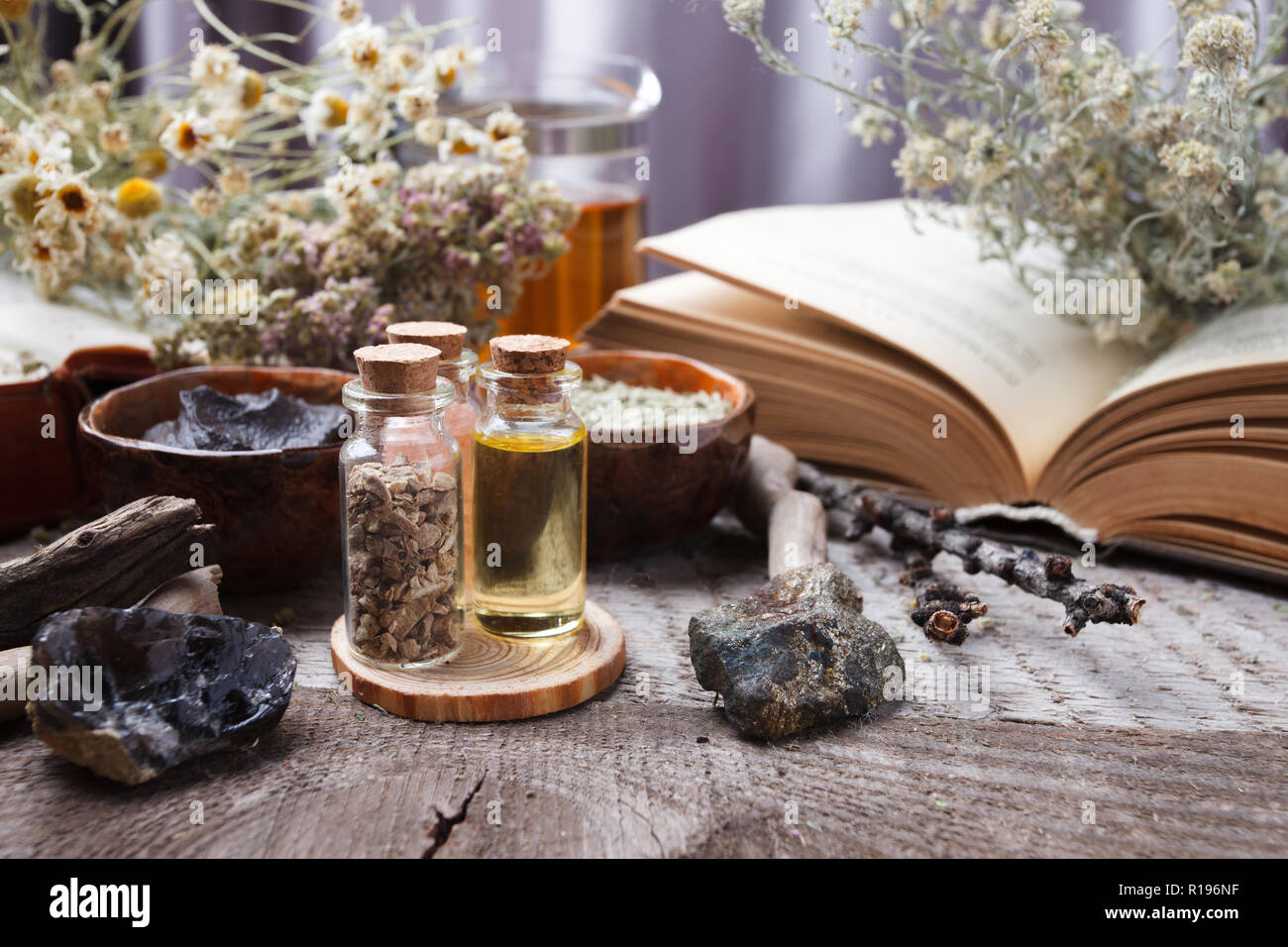 Mystische Stillleben mit alten Buch, Amulette, Stein, Flaschen. Hexerei Komposition. Halloween und okkulten Konzept, magischen Ritual. mystische und homöopathische Stockfoto