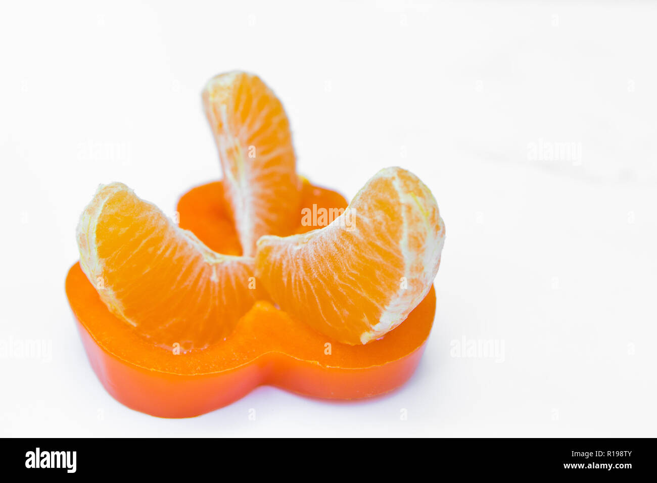 Orange in Scheiben geschnitten Pfeffer und mandarin Draufsicht auf weißem Hintergrund Stockfoto