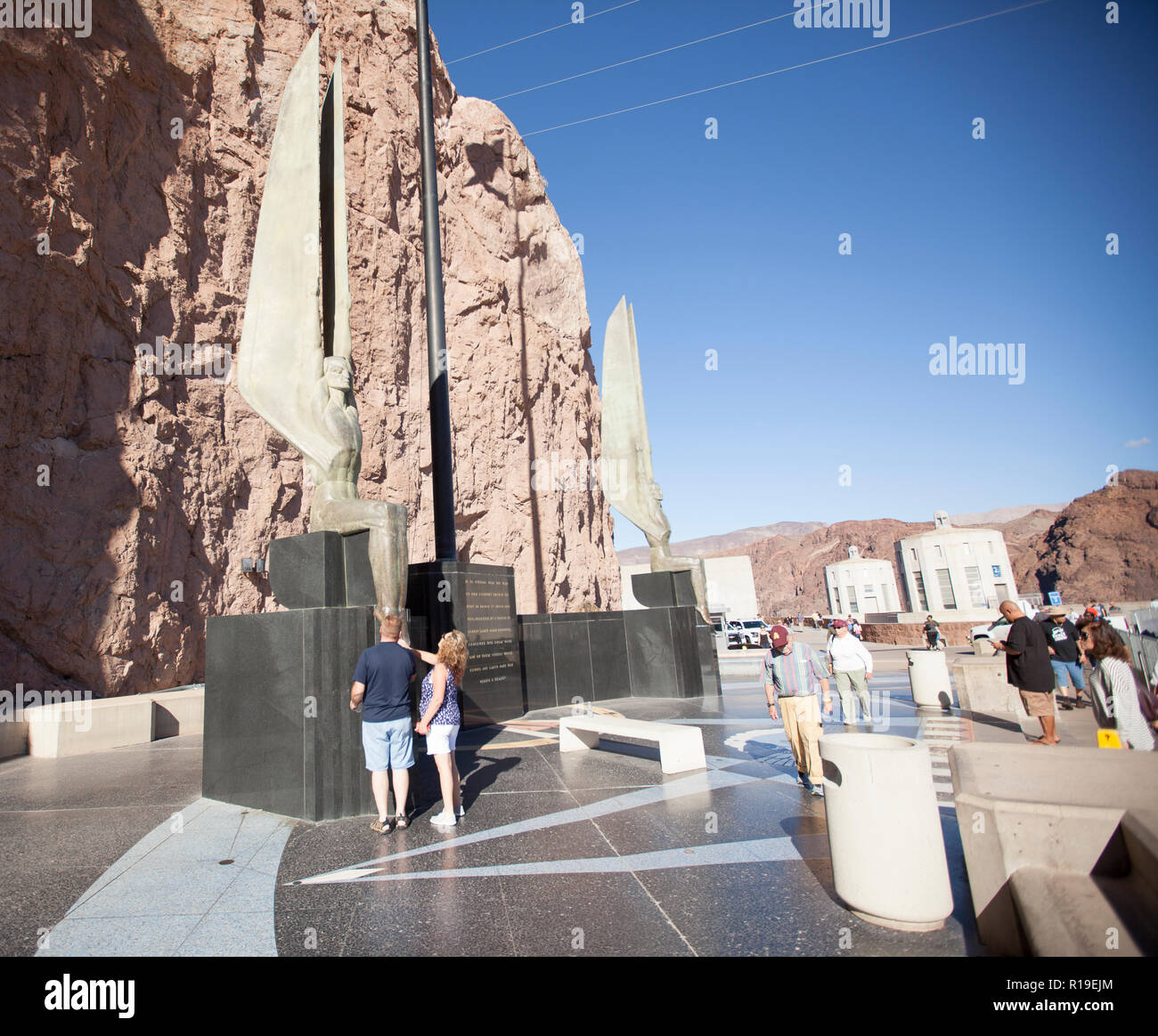 Zwei steigende Zahlen Flanke ein 142-Fuss-fahnenmast an der Hoover Dam Visitors Center, zu den Grünspan-patina, klammert sich an Bronze nach Jahren im Alter von Stockfoto Zwei steigende Zahlen Flanke ein 142-Fuss-fahnenmast an der Hoover Dam Visitors Center, zu den Grünspan-patina, klammert sich an Bronze nach Jahren im Alter von Stockfoto