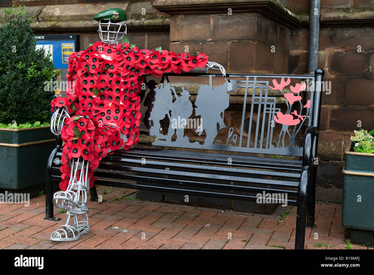 Hereford, Großbritannien. 10 Nov, 2018. HEREFORD, Großbritannien - 10 November: eine Statue von einem Soldaten in Mohnblumen außerhalb Hereford St Peters Kirche sitzt am 10. November 2018 in Leominster, Großbritannien geschmückt. Der Waffenstillstand endet der Erste Weltkrieg zwischen den Alliierten und Deutschland in Compiegne, Frankreich auf der elften Stunde des elften Tag der elenenth Monat unterzeichnet wurde - 11 auf den 11. November 1918 Kredit bin: Jim Holz/Alamy leben Nachrichten Stockfoto