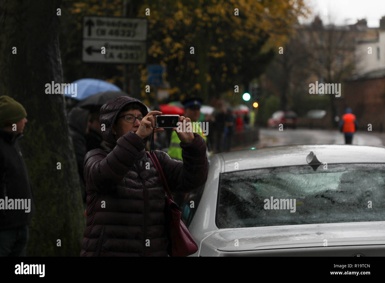 Cheltenham, UK. 10 Nov, 2018. Eine bypasser Fotos, die mit einem iPhone auf der Cheltenham Gedenkmarsch Credit: Victor Storublev/Alamy leben Nachrichten Stockfoto