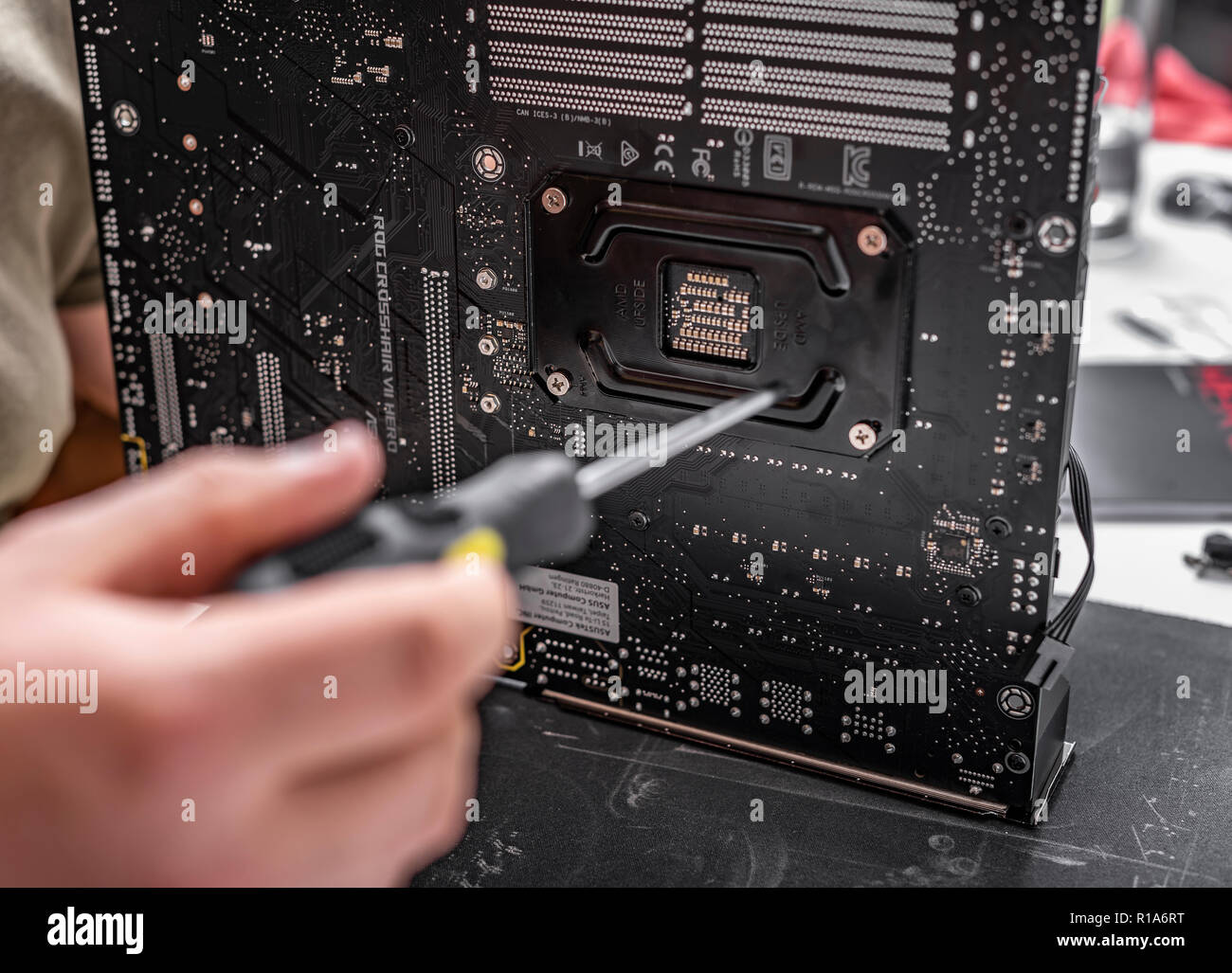 Der Spezialist installiert einen Kühler auf dem neuen Prozessor vor dem Hintergrund einer computer Motherboard Asus rog Fadenkreuz vii Held. Stockfoto