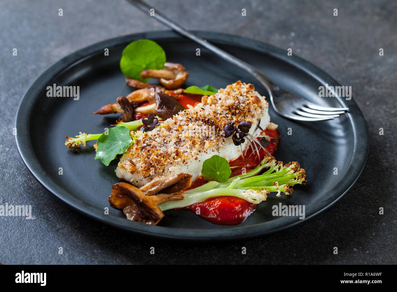 Heilbutt mit Haselnuss Kruste mit gebratenem roten Pfeffer, Spargel, Blumenkohl und Shiitake Pilze Stockfoto