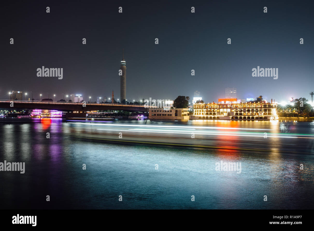 Cairo City Center bei Nacht, Langzeitbelichtung mit leichten Spuren von sich bewegenden Boote auf dem Nil. Stockfoto