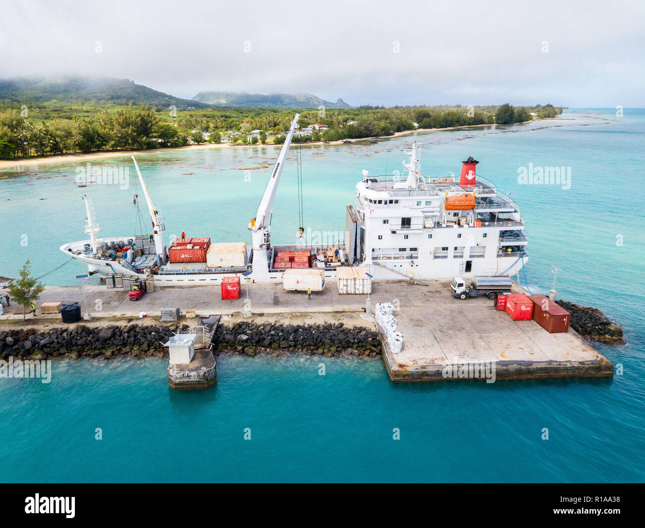 Luftaufnahme von tubuai Insel und Azure türkisblaue Lagune. Schiff Tuhaa Pae IV Entladen im Hafen von Mataura, Australs, Französisch-Polynesien, Ozeanien. Stockfoto