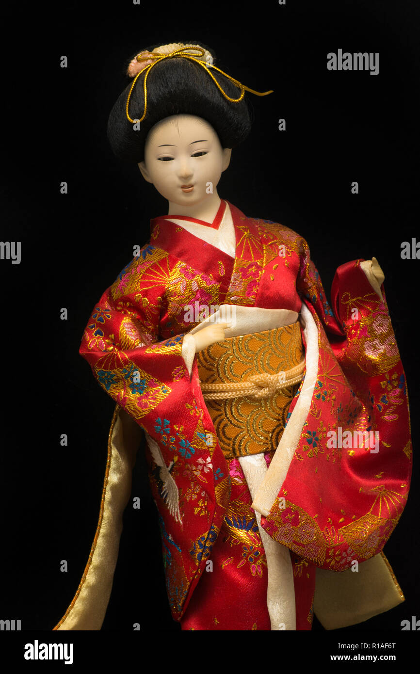 Japanischen Geisha Puppe in rot Kimono auf schwarzem Hintergrund Stockfoto