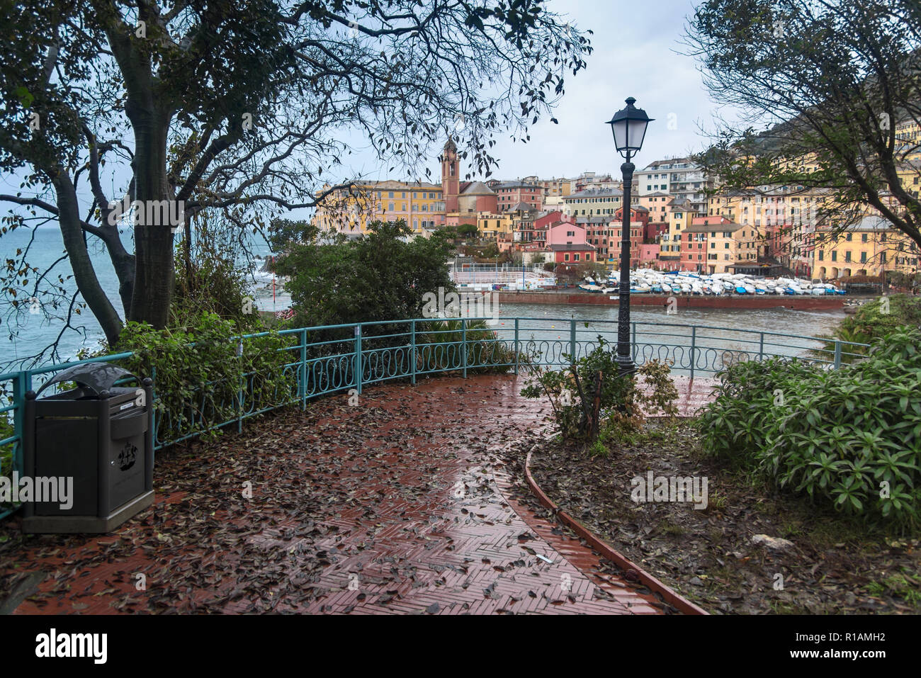 Blätter im Herbst am malerischen Ufer Laufsteg mit Straßenlaterne und schöne Bäume. Italienische Stadt mit Yachten im Abstand günstig Stockfoto