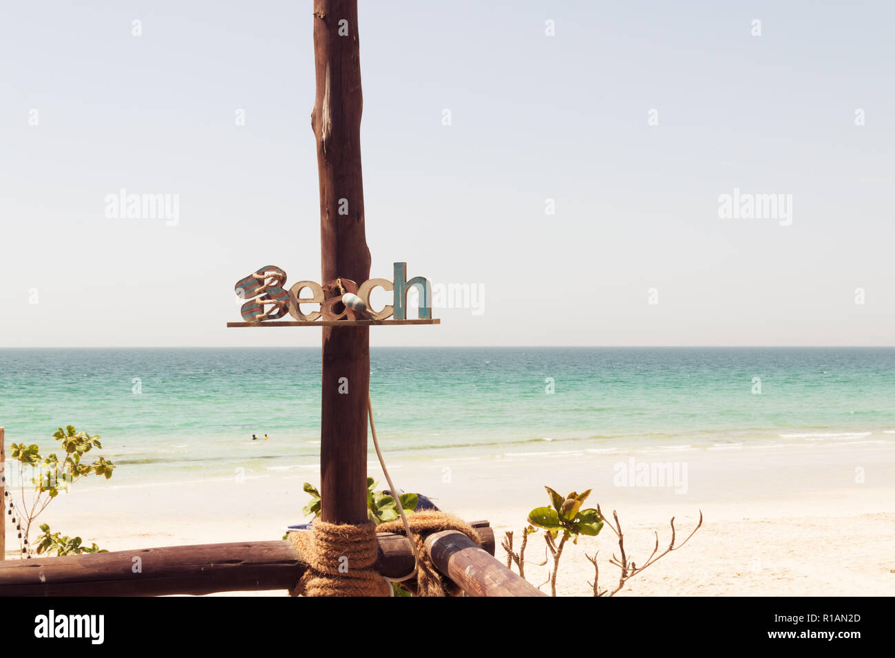 Holz- Strand anmelden Sommer Strand Inschrift, Rest, Sand, Meer. Holz- Plakette mit der Aufschrift Strand auf einer Platte, Meer Hintergrund. Berufung Dekorationen. Stockfoto