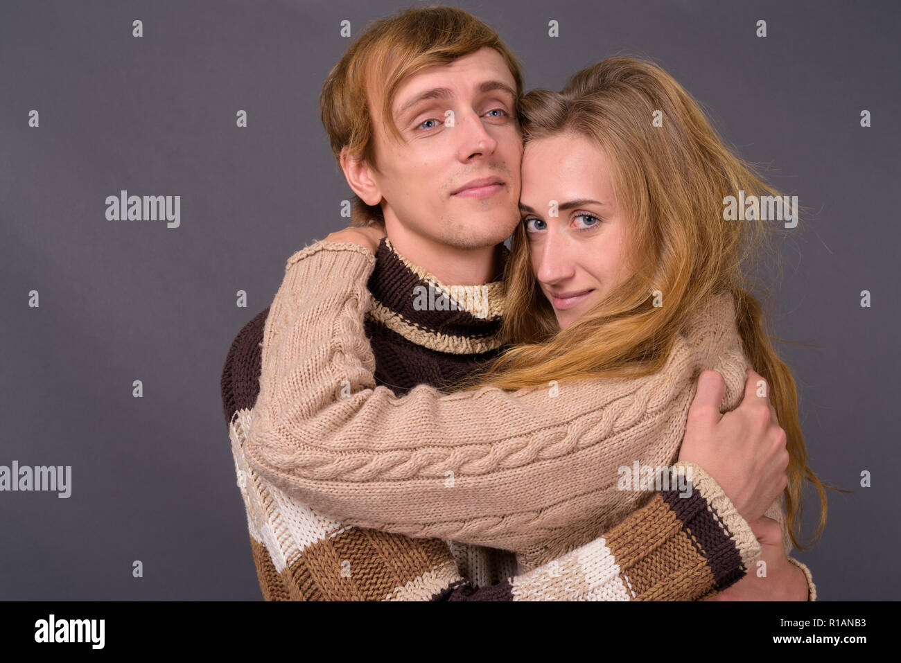 Studio Aufnahme des jungen Paares gemeinsam gegen grauer Hintergrund Stockfoto