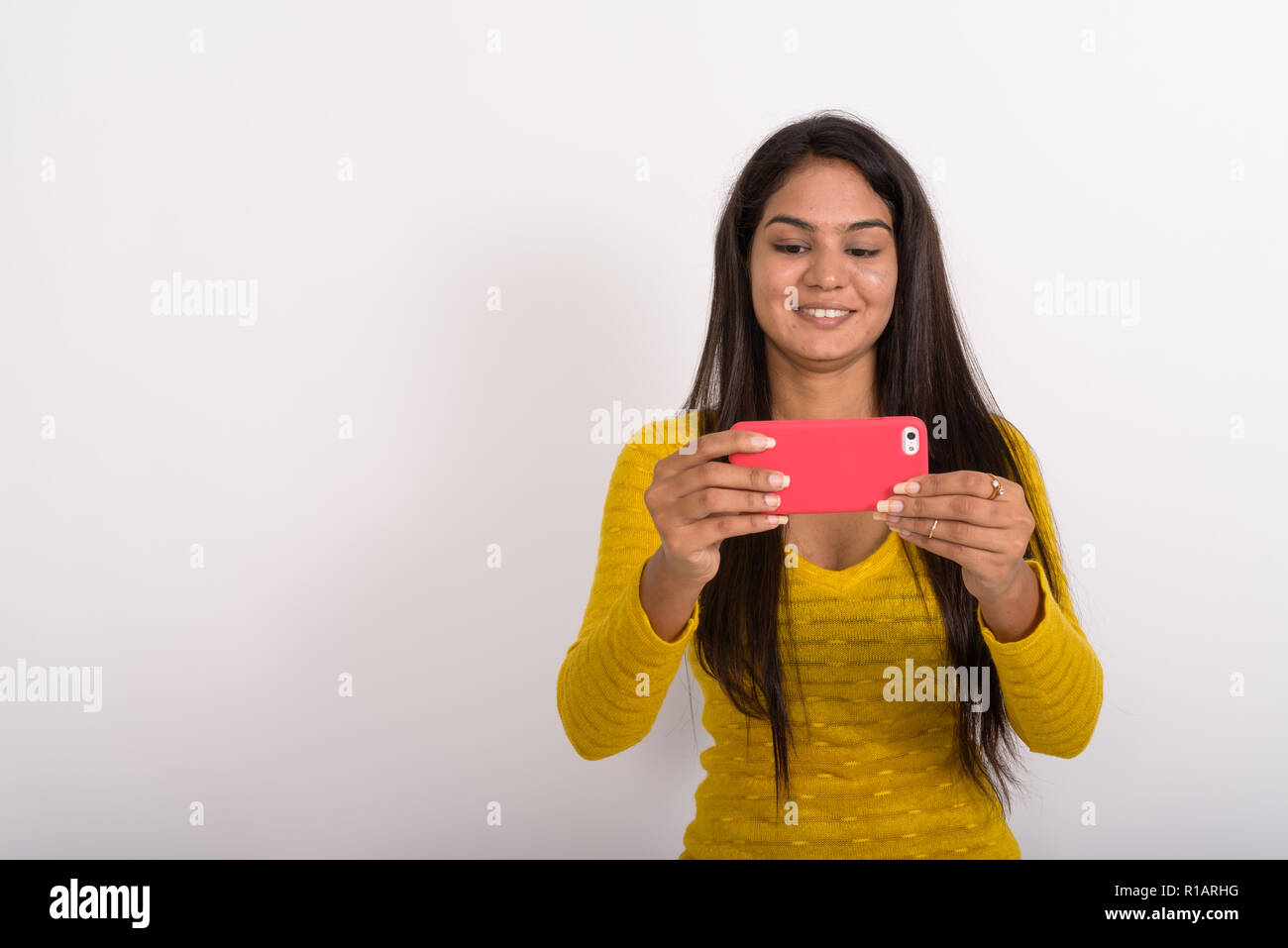 Studio shot der jungen indischen Glücklich lächelnde Frau während der pic Stockfoto