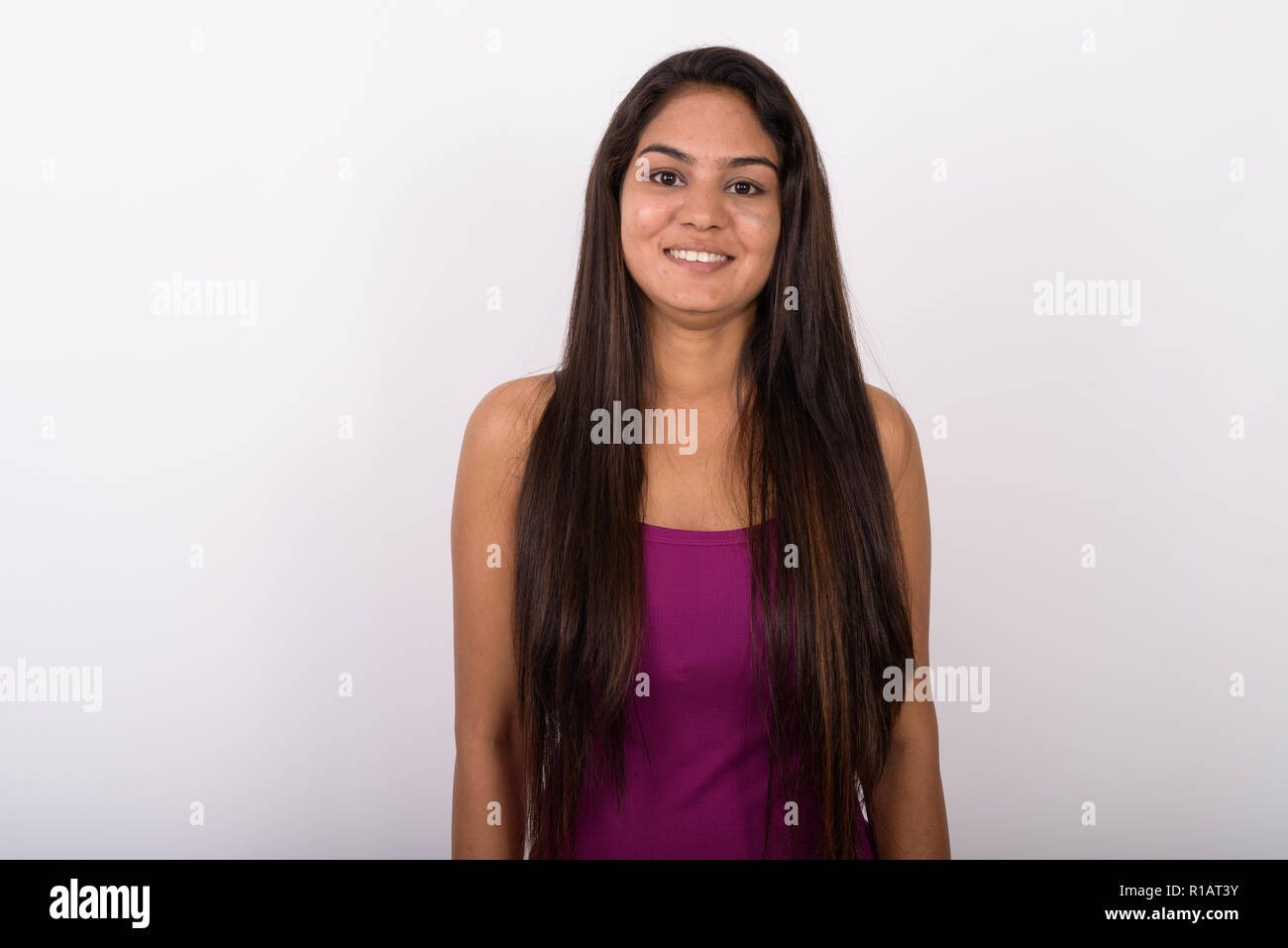 Studio shot der jungen indischen Glücklich lächelnde Frau beim Tragen sl Stockfoto