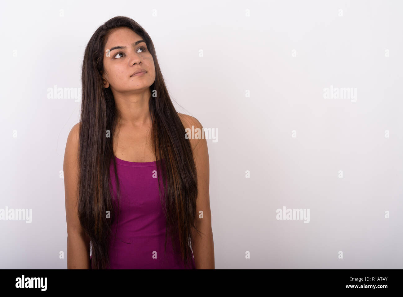 Studio shot der jungen indischen Frau denken, während mit der Suche und Stockfoto