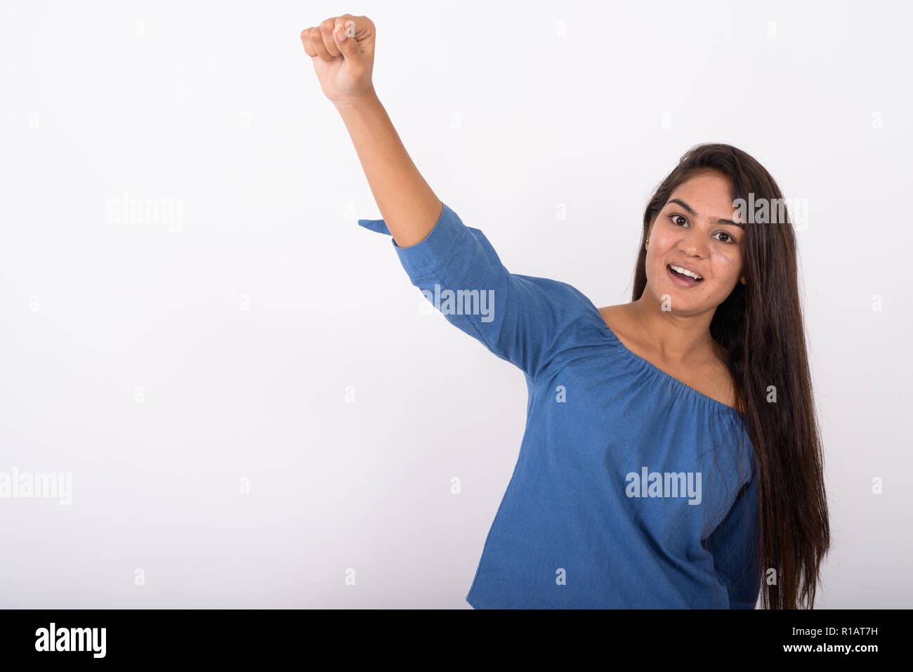 Studio shot der jungen indischen Glücklich lächelnde Frau, während sie Mo Stockfoto