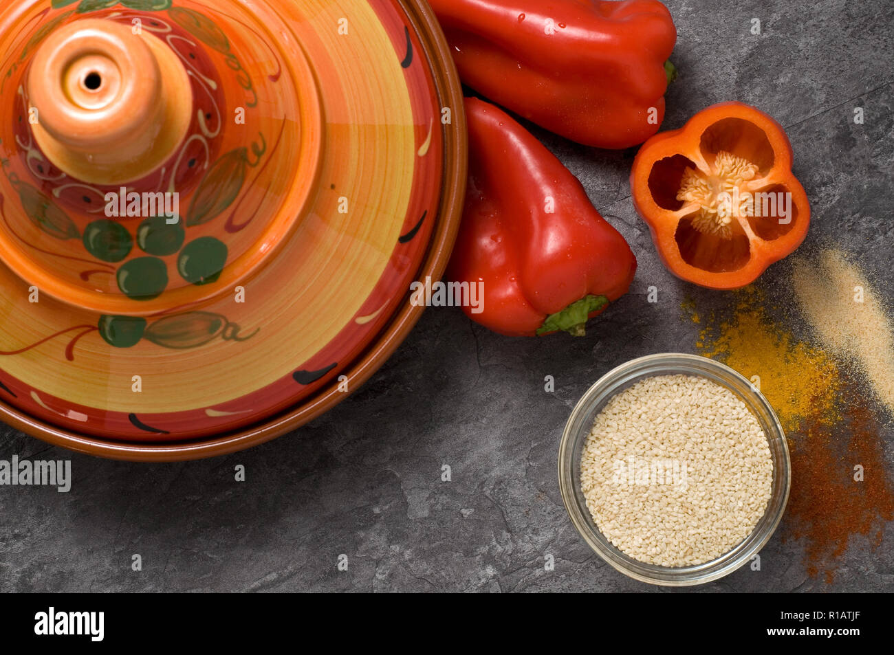 Bunte rote Kochmesser mit frischem Paprika, Gewürze, Tajine auf Granit Zähler Stockfoto