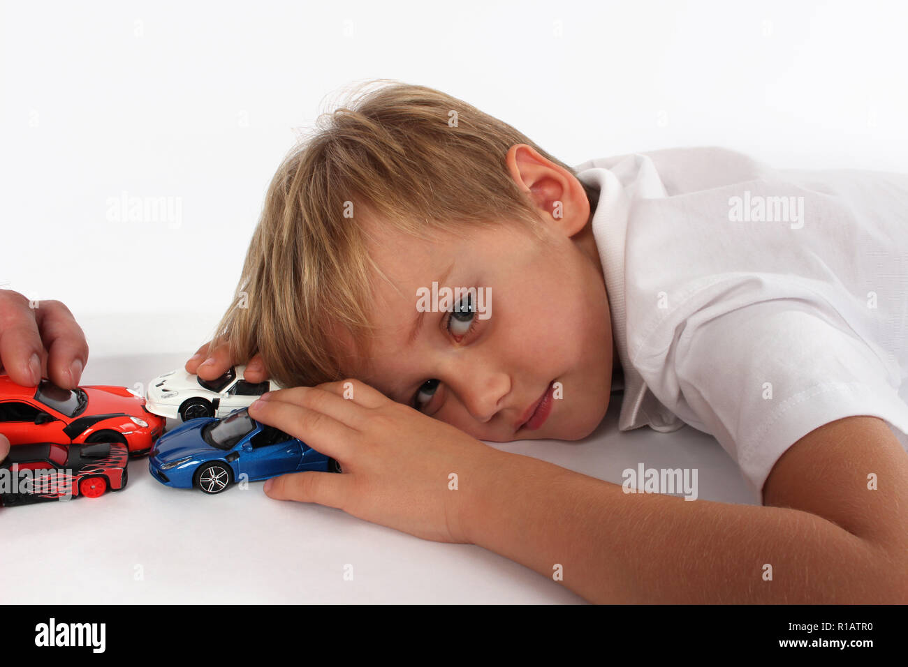 Cute blond blaue Augen kleiner Junge spielt mit dem Auto Spielzeug  Stockfotografie - Alamy