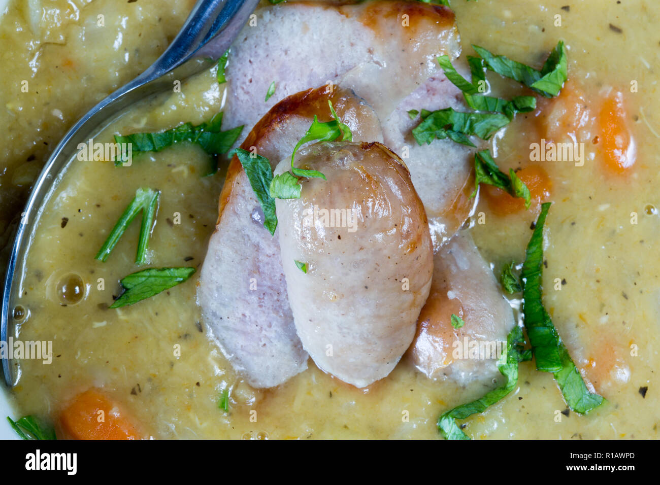 Polnische Zurek oder Gemüsesuppe mit Wurst und Petersilie garnieren. Stockfoto