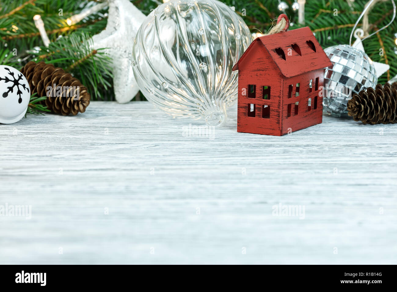 Christbaumschmuck, Bälle, dekorative rote kleines Haus und Grüne Tanne Baum auf weißem Schreibtisch aus Holz Stockfoto