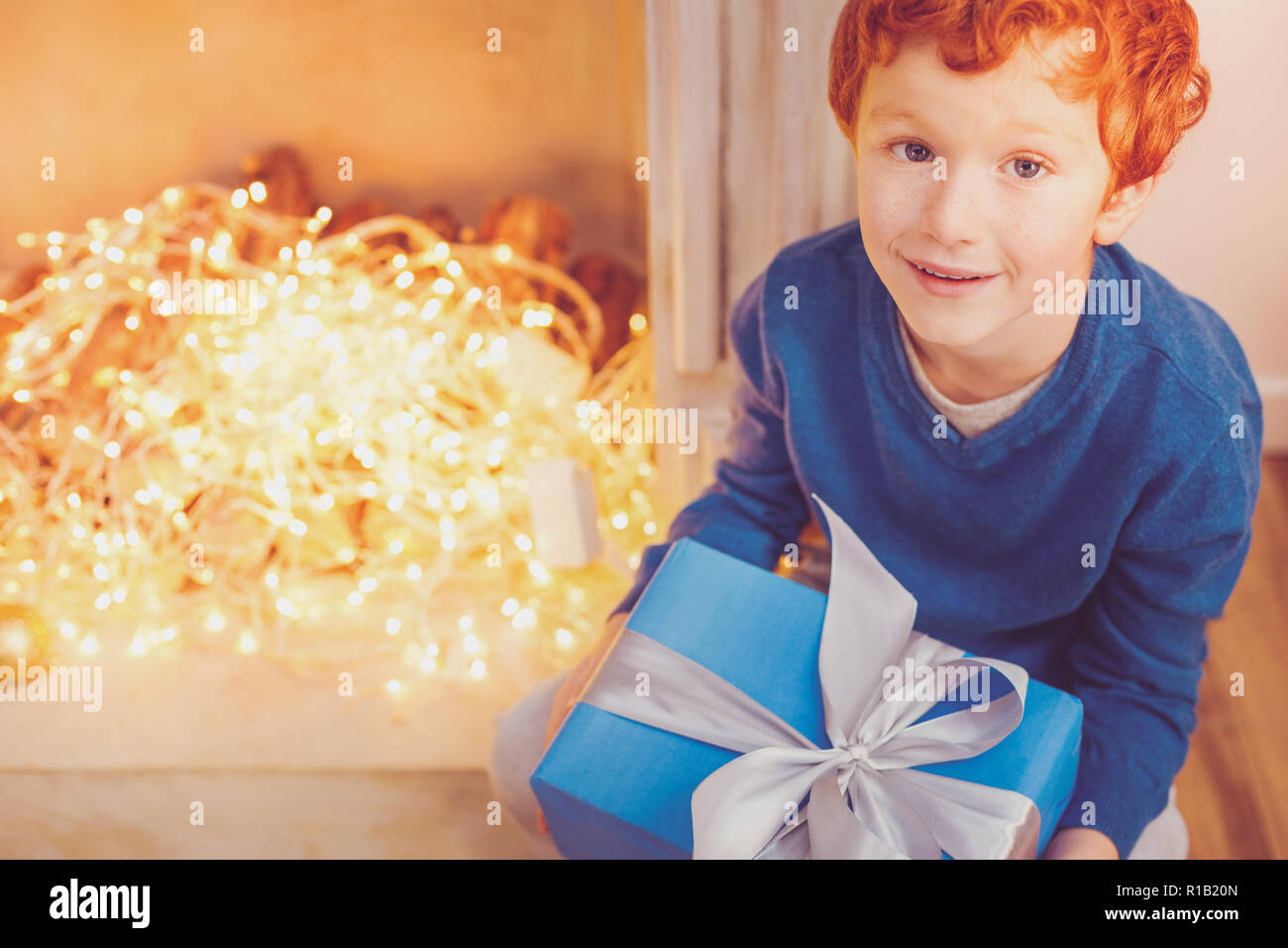 Blick von oben auf die rothaarige Junge holding Weihnachtsgeschenk Stockfoto