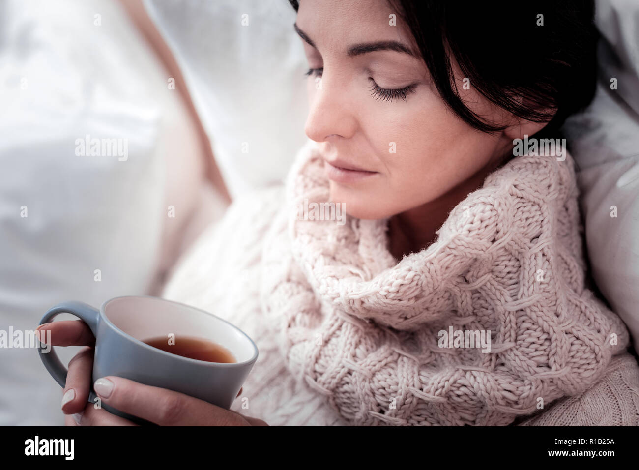 Der nachdenkliche Frau mit einer Tasse Tee Stockfoto