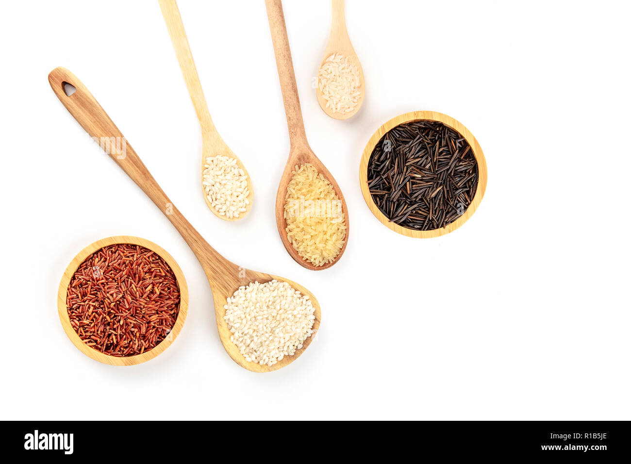 Ein Foto von verschiedenen Arten von Reis, geschossen von oben auf einen weißen Hintergrund mit kopieren. Weiß, Rot, Braun und Schwarz rices mit einem Platz für Text Stockfoto