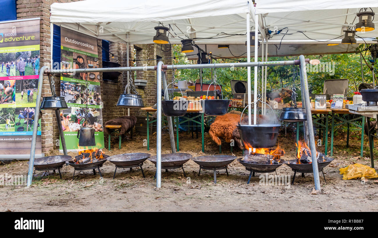 Kochen im Freien n eisernen Töpfen auf offenem Feuer in einem Wald bei einem Wildlife Ereignis in Ede in den Niederlanden Stockfoto