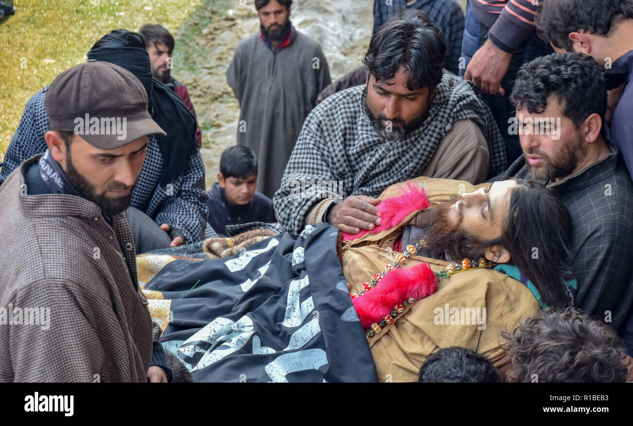 (Anmerkung des Editors: Das Bild zeigt den Tod.) die Verwandten des Getöteten militanten Liyakat Ahmed gesehen werden neben seiner Leiche während seiner Beerdigung Prozession versammelt in seinem Heimatdorf in Pulwama. Tausende von Menschen haben in der Beerdigung Gebete der beiden Kämpfer, der in einer Schießerei mit den Regierungstruppen im Süden von Kaschmir Pulwama Bezirk 40 km vom Sommer Hauptstadt Srinagar getötet wurden, teilgenommen. Die Militanten, entsprechend Generalinspektor der Polizei, Kaschmir, SP Pani, wurden in einer "sehr kurzen "Shootout im Tikken Dorf getötet. Stockfoto