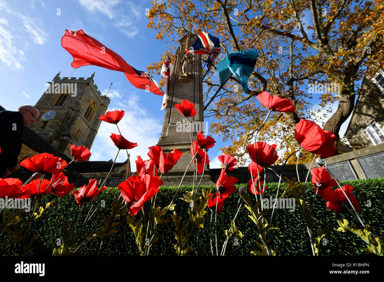 Bridport, Dorset, Großbritannien. 11. November 2018. Mohnblumen und das Kriegerdenkmal mit Fahnen auf das Gedenken Sonntag außerhalb der Kirche St. Mary in South Street fliegen in Bridport. Die 2018 Tag der Erinnerung fällt auf das 100-jährige Jubiläum des Waffenstillstandes Tag, der das Ende des ersten Weltkriegs markiert. Foto: Graham Jagd-/Alamy leben Nachrichten Stockfoto