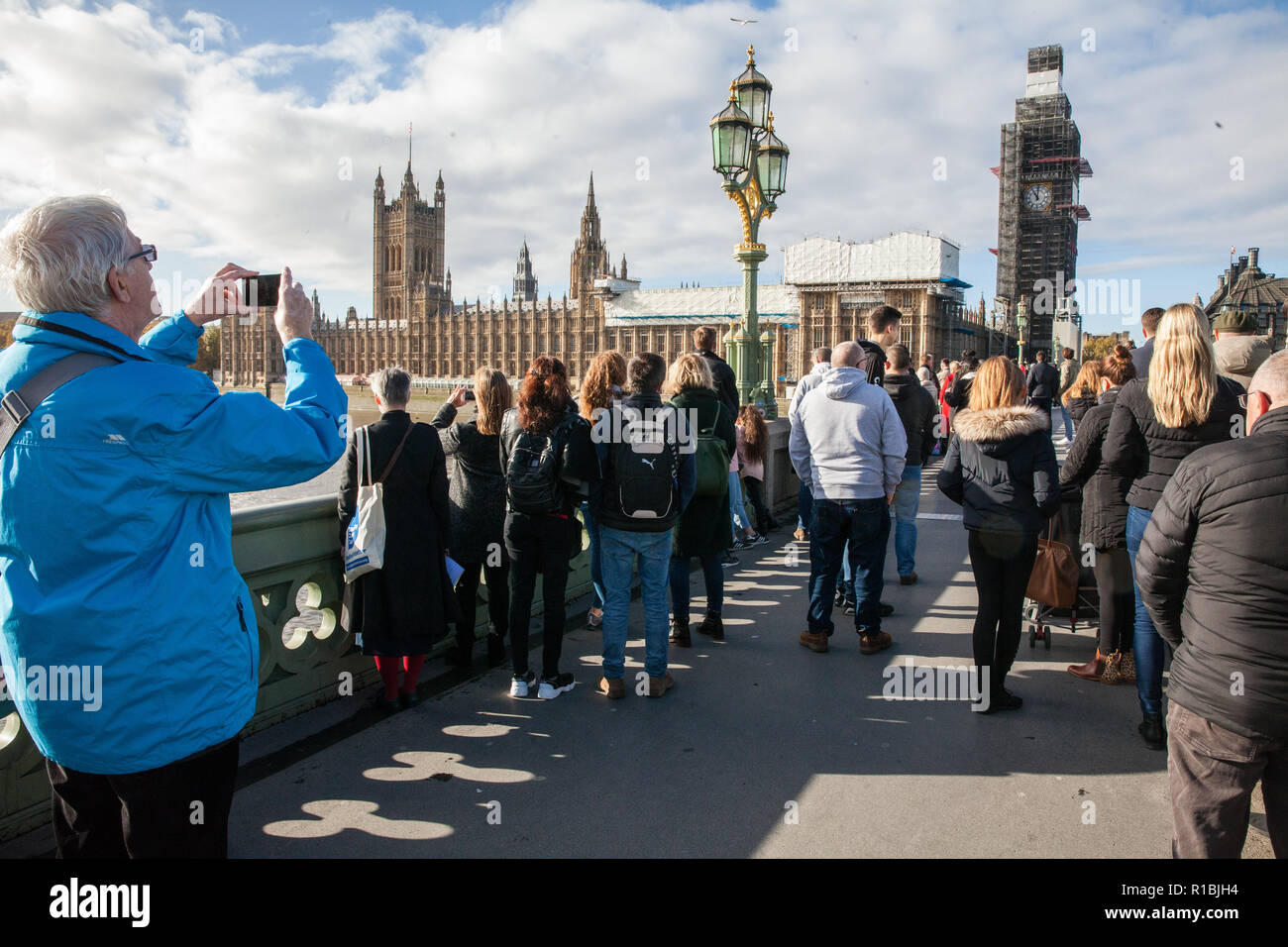 London, Großbritannien. 11 Nov, 2018. Mitglieder der Öffentlichkeit auf die Westminster Bridge hören sie leise mit dem Glockenspiel von Big Ben die elfte Stunde des elften Tag des elften Monats in Gedenken auf das Gedenken Sonntag der 100. Jahrestag der Unterzeichnung der Waffenstillstand, dem Ende des Ersten Weltkriegs markiert zu markieren. Credit: Mark Kerrison/Alamy leben Nachrichten Stockfoto