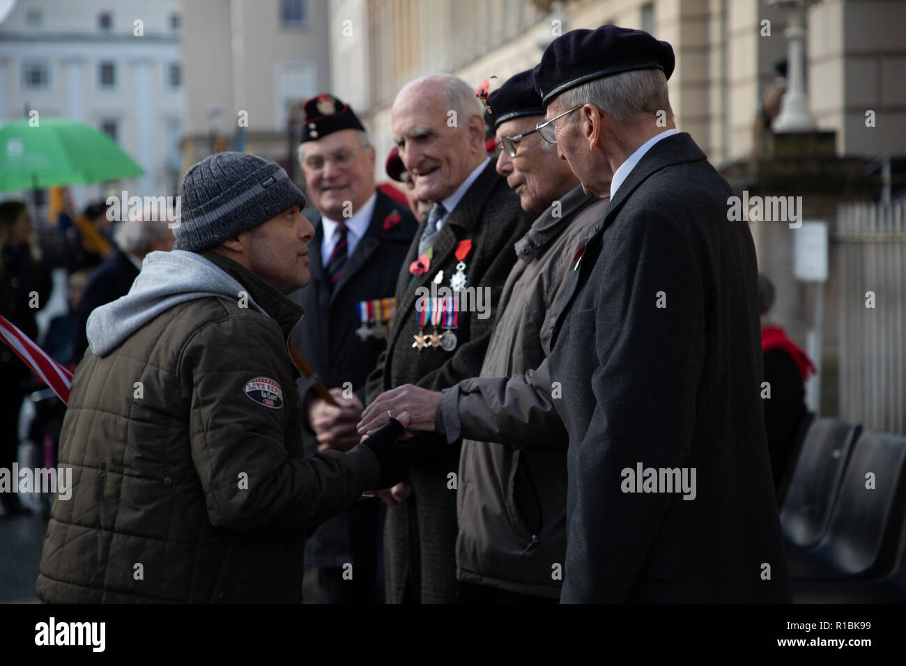 Cheltenham, UK. 11 Nov, 2018. Ein Mann die Hände schütteln und Gruß Veteranen Credit: Victor Storublev/Alamy leben Nachrichten Stockfoto