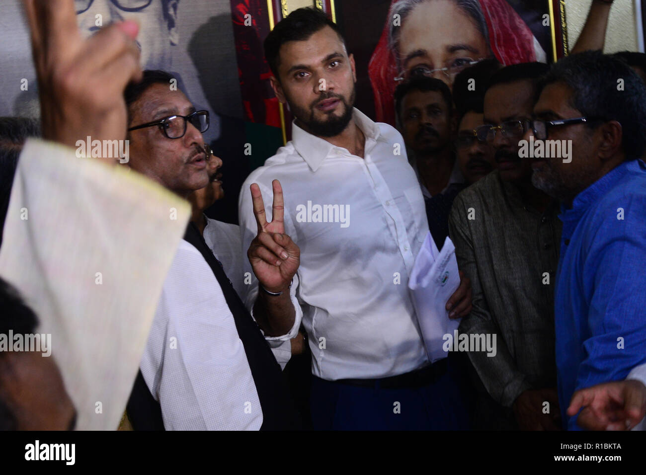 Bangladesch. 11 Nov, 2018. Bangladesch ein Tag International (ODI) Cricket captain Mashrafe Bin Mortaza (C) erfasst eine Nomination Form von Awami League Dhanmondi Büro am Sonntag, 11 November, 2018 die anstehenden 11 Wahlen mit Awami League Ticket von Narail-2 Wahlkreis zu bestreiten. Credit: Mamunur Rashid/Alamy leben Nachrichten Stockfoto