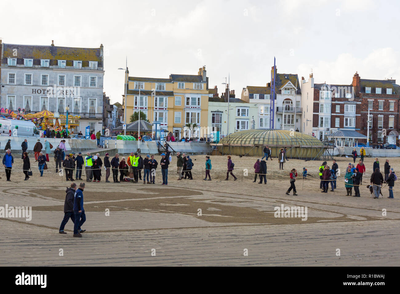 Dorchester, Dorset UK. 11. Nov 2018. Gemeinschaften in Großbritannien sammeln auf Stränden zu 100 Jahre seit dem Waffenstillstand und dem Ende des Ersten Weltkriegs markieren; zu sagen Danke und auf Wiedersehen, die Millionen von Männern und Frauen, die ihre Ufer während des Krieges verlassen, viele nie zurück. Danny Boyle's einzigartigen Seiten des Meeres, wo ein Porträt eines Einzelnen aus dem Ersten WK1 aus dem Sand entsteht und dann, als die Flut steigt, es ist weggespült Credit: Carolyn Jenkins/Alamy leben Nachrichten Stockfoto