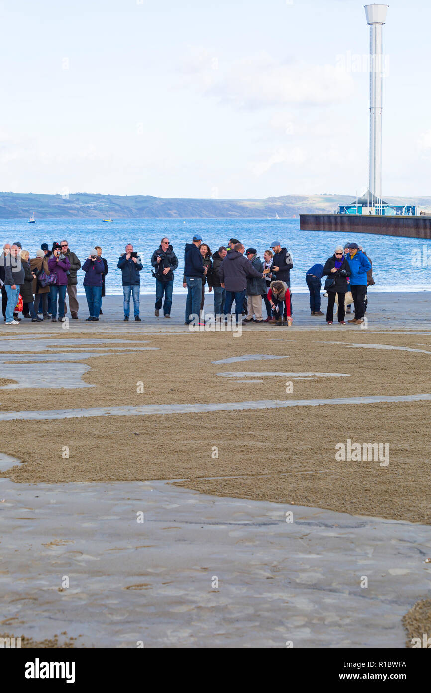 Dorchester, Dorset UK. 11. Nov 2018. Gemeinschaften in Großbritannien sammeln auf Stränden zu 100 Jahre seit dem Waffenstillstand und dem Ende des Ersten Weltkriegs markieren; zu sagen Danke und auf Wiedersehen, die Millionen von Männern und Frauen, die ihre Ufer während des Krieges verlassen, viele nie zurück. Danny Boyle's einzigartigen Seiten des Meeres, wo ein Porträt eines Einzelnen aus dem Ersten WK1 aus dem Sand entsteht und dann, als die Flut steigt, es ist weggespült. Credit: Carolyn Jenkins/Alamy leben Nachrichten Stockfoto